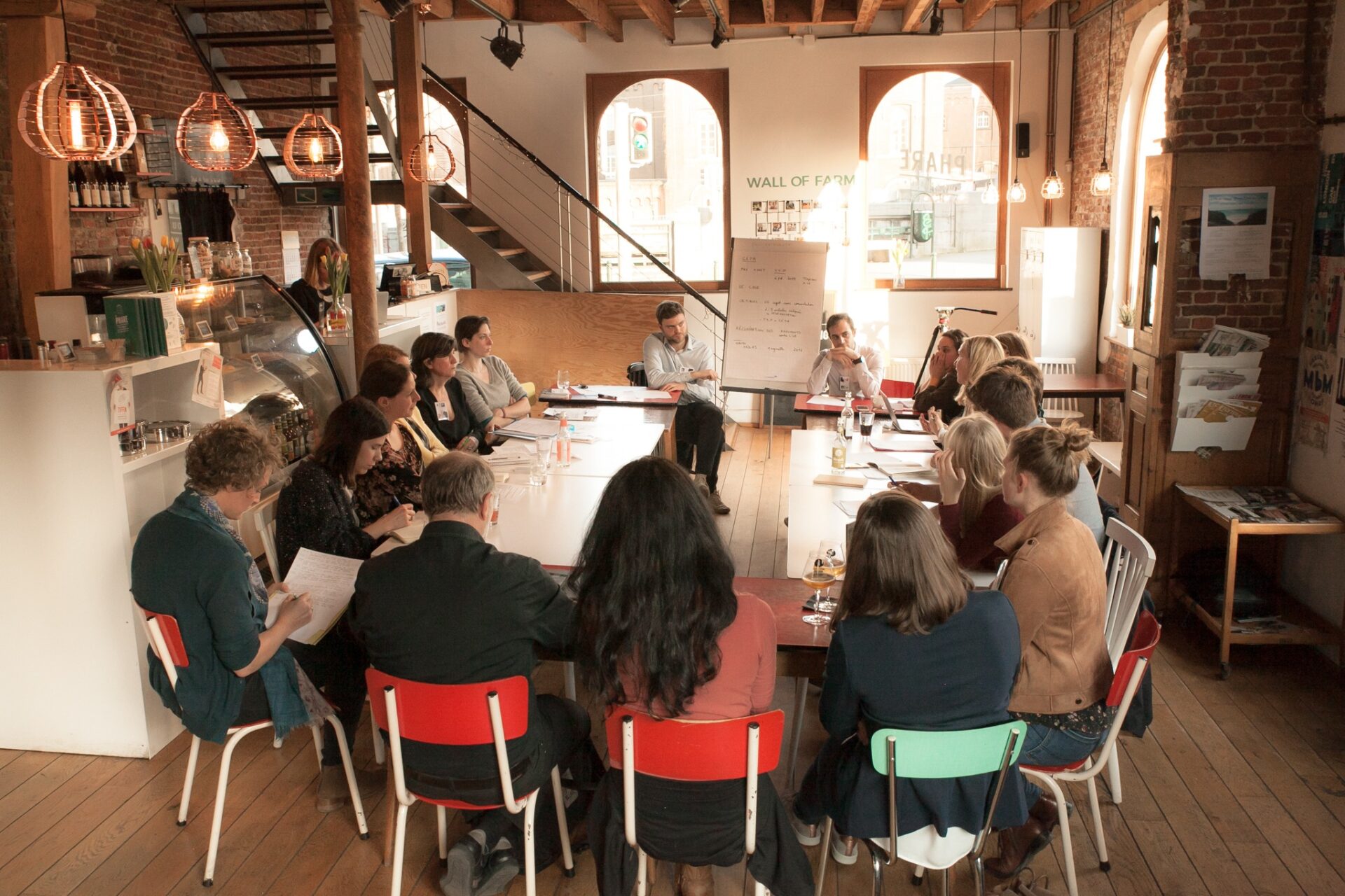 People working around a long table in the café.